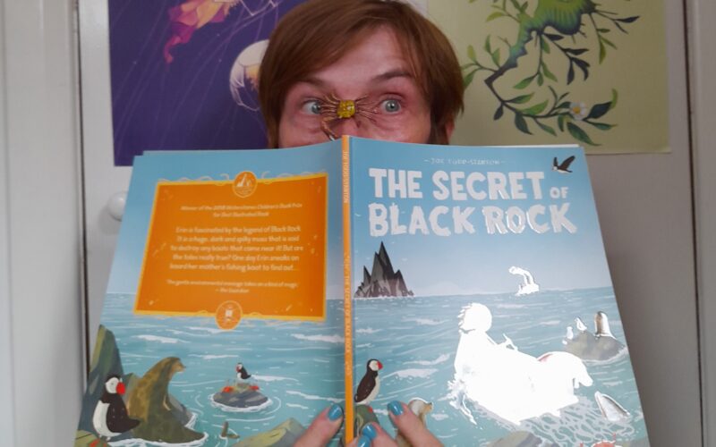Beata holding the book The Secret of Black Rock
