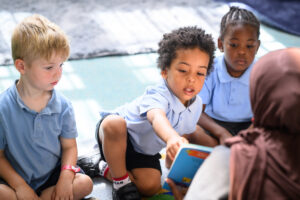3 children look at a picture book