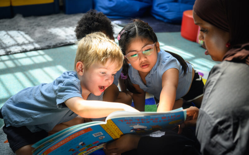 Children pointing to a story book