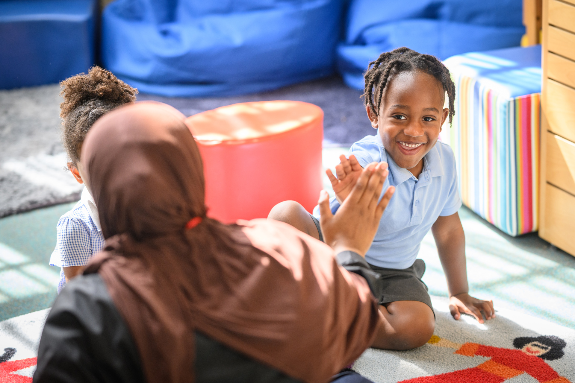 Photo of a child high fiving their tutor